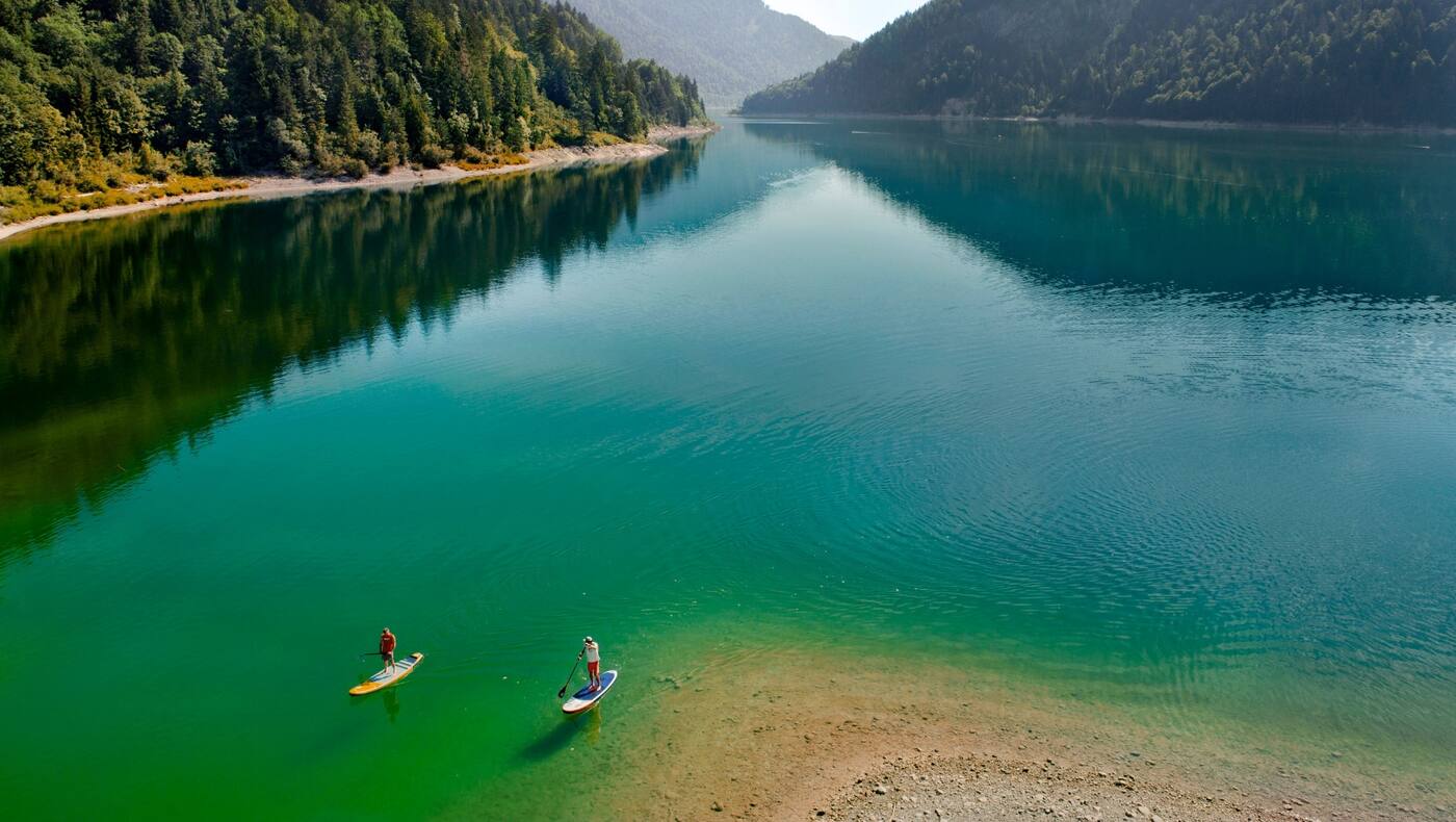 Zwei Sportler alleine am See.