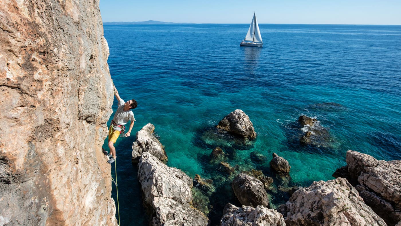 Kletterer am Fels über dem Meer in Kroatien