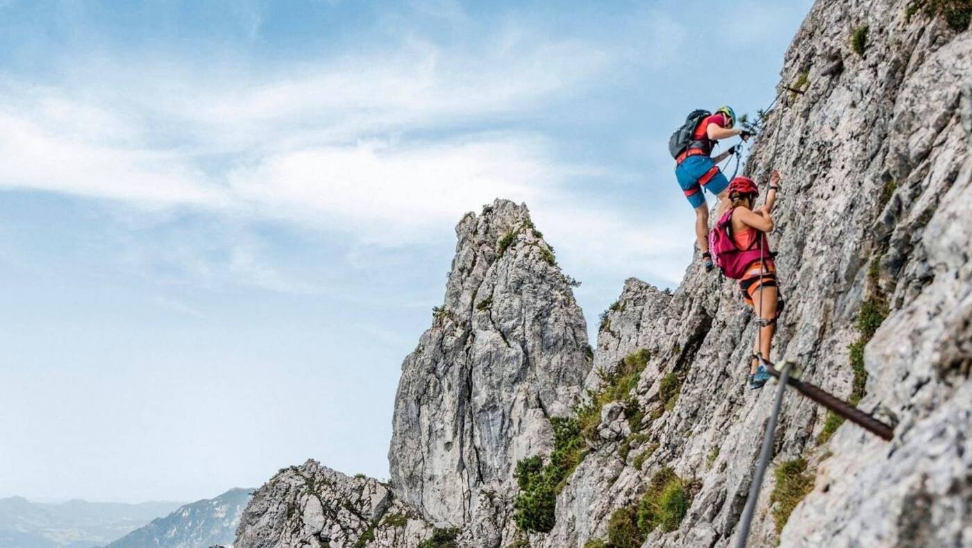 Kletterer am Pidinger Klettersteig und im Hintergrund das Alpenvorland
