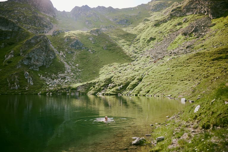 Bergsee Person schwimmt
