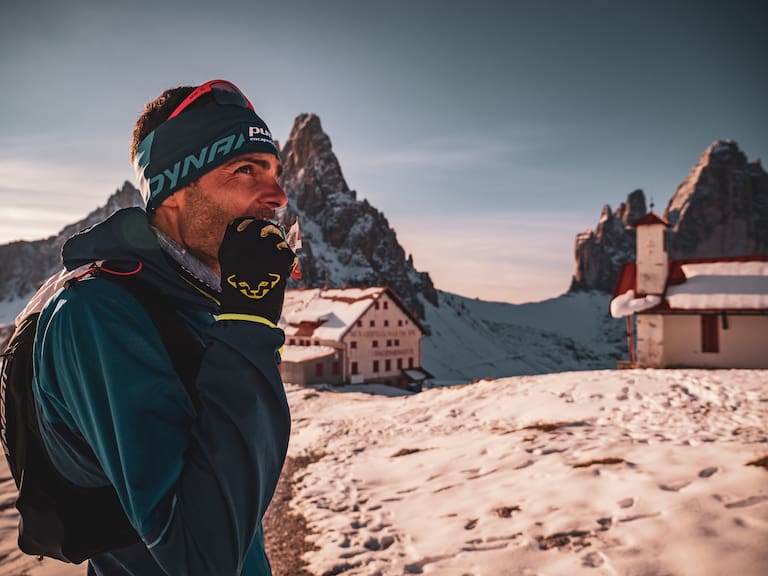 Jakob Herrmann gönnt sich einen Snack während dem AlpFrontTrail in den Südtiroler Dolomiten, die Drei Zinnen im Hintergrund