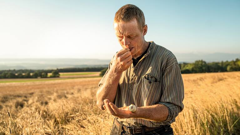 Kurz vor der Ernte prüft Cédric Chezeaux im Feld die Feuchtigkeit und den Geschmack des Korns.