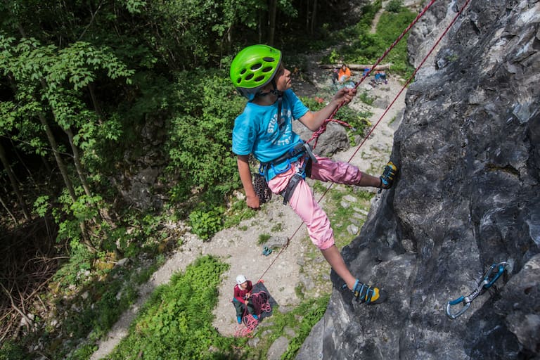 Kind beim Klettern am Fels