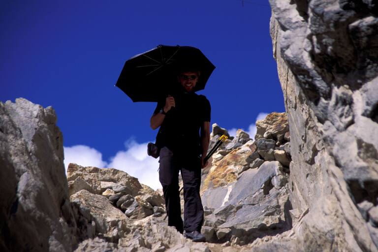 Hitze im Gebirge: Bergsteiger mit Sonnenschirm
