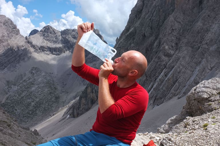 Hitze am Berg: Bergsteiger beim Trinken von Wasser