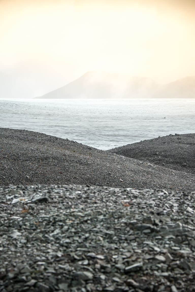 Der Skálafellsjökull am nebligen Horizont mit dunklen Kiesstränden und Meer im Vordergrund 