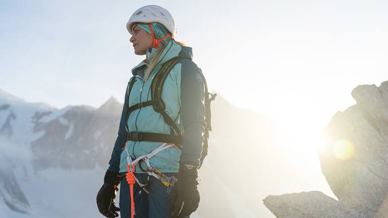 Frau steht auf einem Berg in La Sportiva Ausrüstung zum Klettern
