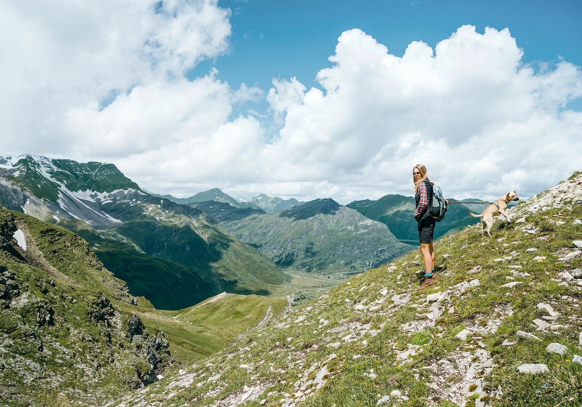 Eine Wanderin genießt den Ausblick auf die Berglandschaft.