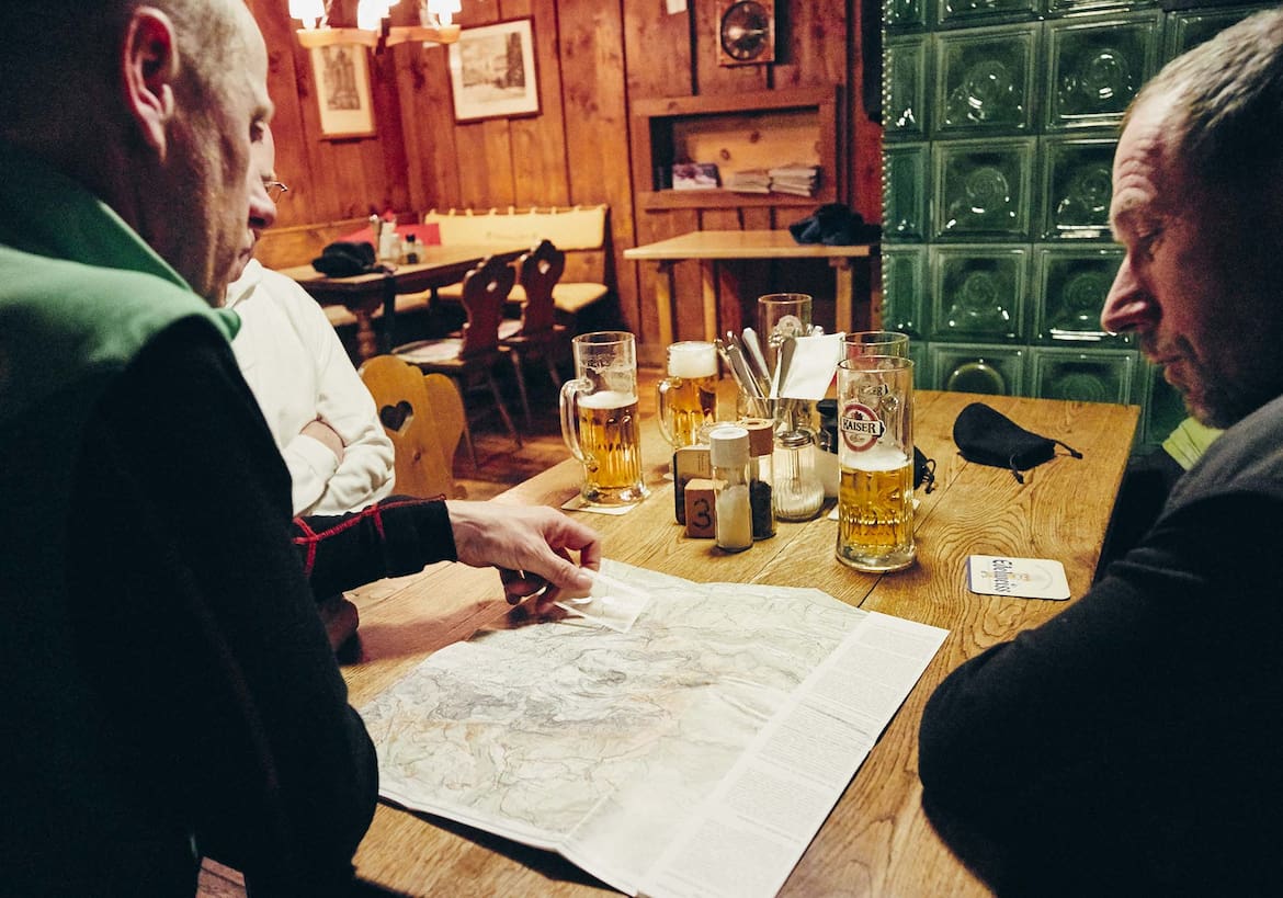 Die Crew sitzt vor einen Karte in der gemütlichen Stube der Ostpreußenhütte.