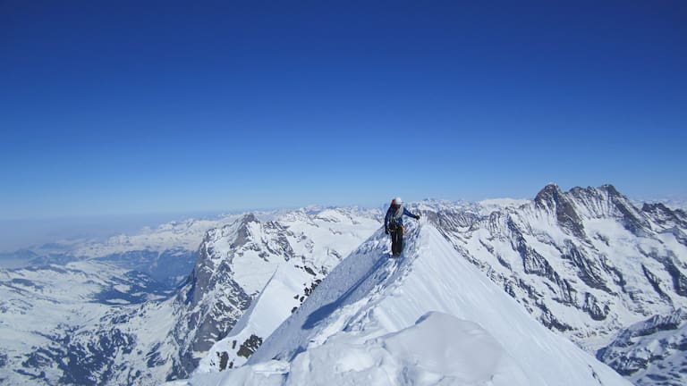 Simon Messner beim Bergsteigen am Gipfelgrat des Eiger