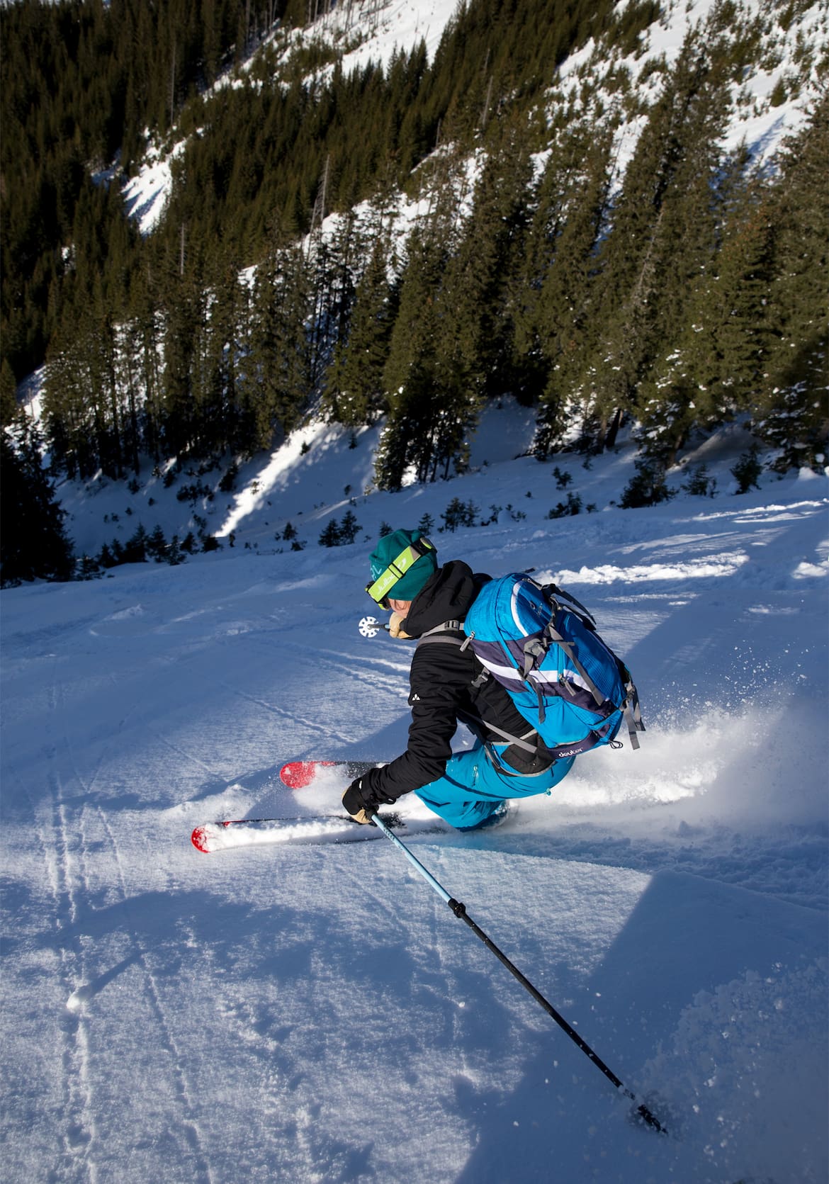 Ein Skifahrer zieht Schwünge auf einer steilen Piste.