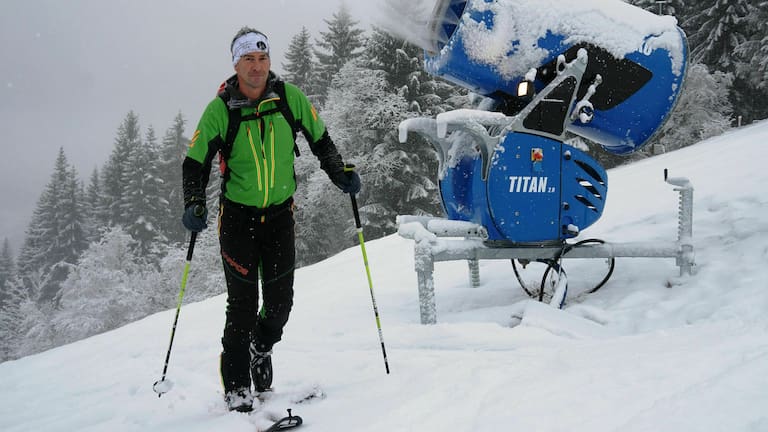 Skitourengeher im Skigebiet auf präparierter Piste