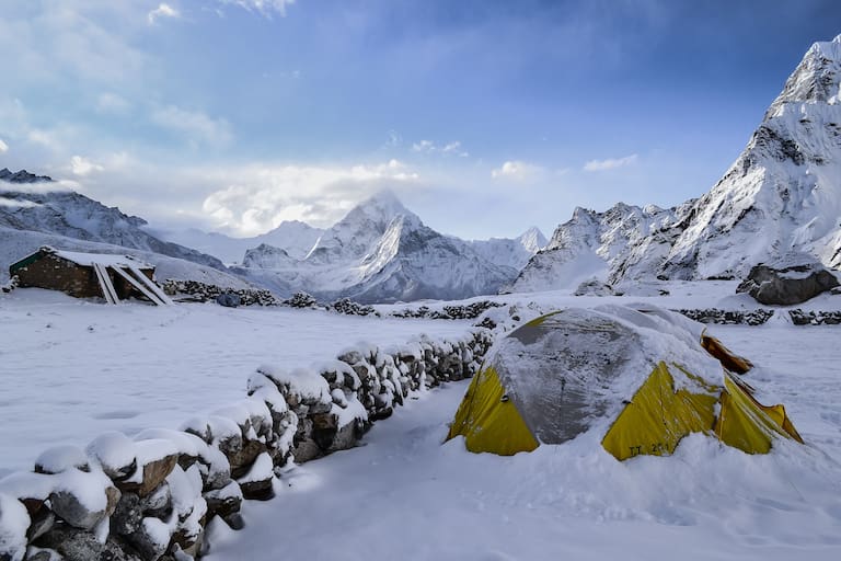 Zelt vor winterlichem Bergpanorama