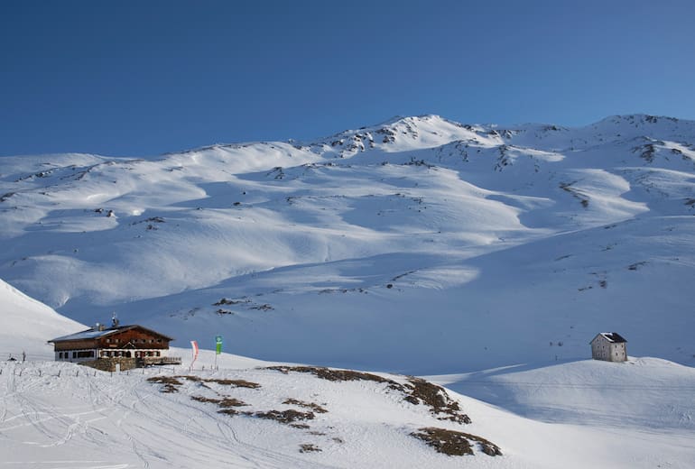 Die Sesvennahütte ist ein perfektes Basislager für Skitourengeher. Hinten die Rasass-Spitze (2.941 m) zum Eingehen.