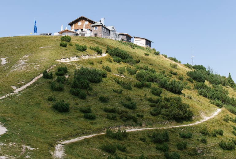Oberhalb von Garmisch-Partenkirchen auf dem Gipfel des Wank im Estergebirge steht das Wankhaus direkt neben dem Gipfelkreuz.